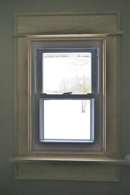 **Defenestration?**

I’ve spent a great many hours over the last week working on my biggest projects yet: window trim. I’ve learned a lot (and purchased a great many tools).  
  

Here’s where we started. As you can see, they have no trim and there is a marble sill. All in all, I’m reminded of the cheap apartment I lived in during college. We’re planning on painting soon, so we decided to add trim first. I started in the master bath because we’re not using it much, so if the project went horribly we could just seal it off and pretend it never happened.  
  
My father helped me come up with a plan. Our house doesn’t have much in the way of trim now, so we were starting with a blank slate: we’ll use the same pattern throughout the house eventually. We decided on a design that will provide some shadow lines but will be simple-looking enough to go with the house’s modern exterior. We chose to use poplar because we intend to paint– we didn’t want a wood with a lot of grain.

  
Here’s the finished product. The side casings are 1x4 and the head casing and apron are 1x6. The back band is 2x2 rabbeted into an L-shape and then trimmed down to ¾ in on the front face and coped to the wall. Originally, we had no back band, a 1x8 head casing, and I planned to install strips of molding at the top of the cap and under the apron. The intent was to make the ceiling look taller, but it was just too much, especially for a tiny bathroom.  
  
I’m delighted with how the window turned out. I still need to fill in the nail holes, sand, and prepare the window for painting. We have two windows to do in our bedroom. I’ll start those just as soon as I figure out how to cram 8 ft boards into the Golf.