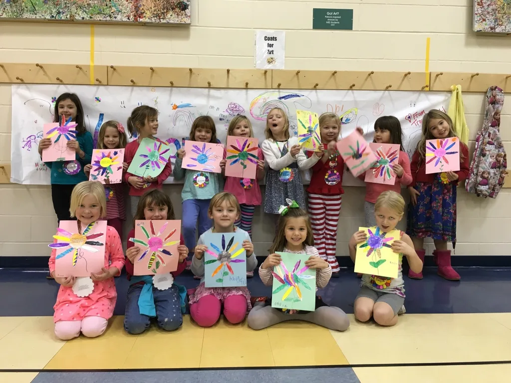 Fourteen Daisy Girl Scouts proudly displaying their finished projects.